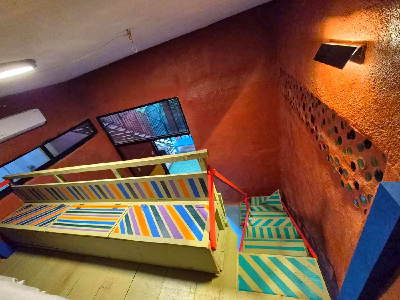 Painted stairs at Two bedroom Delight, teal stripes and a rainbow railing