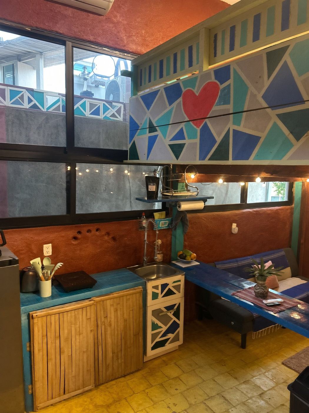 The kitchen at El Loft, bamboo cabinets, a blue counter, and the heart on the loft railing